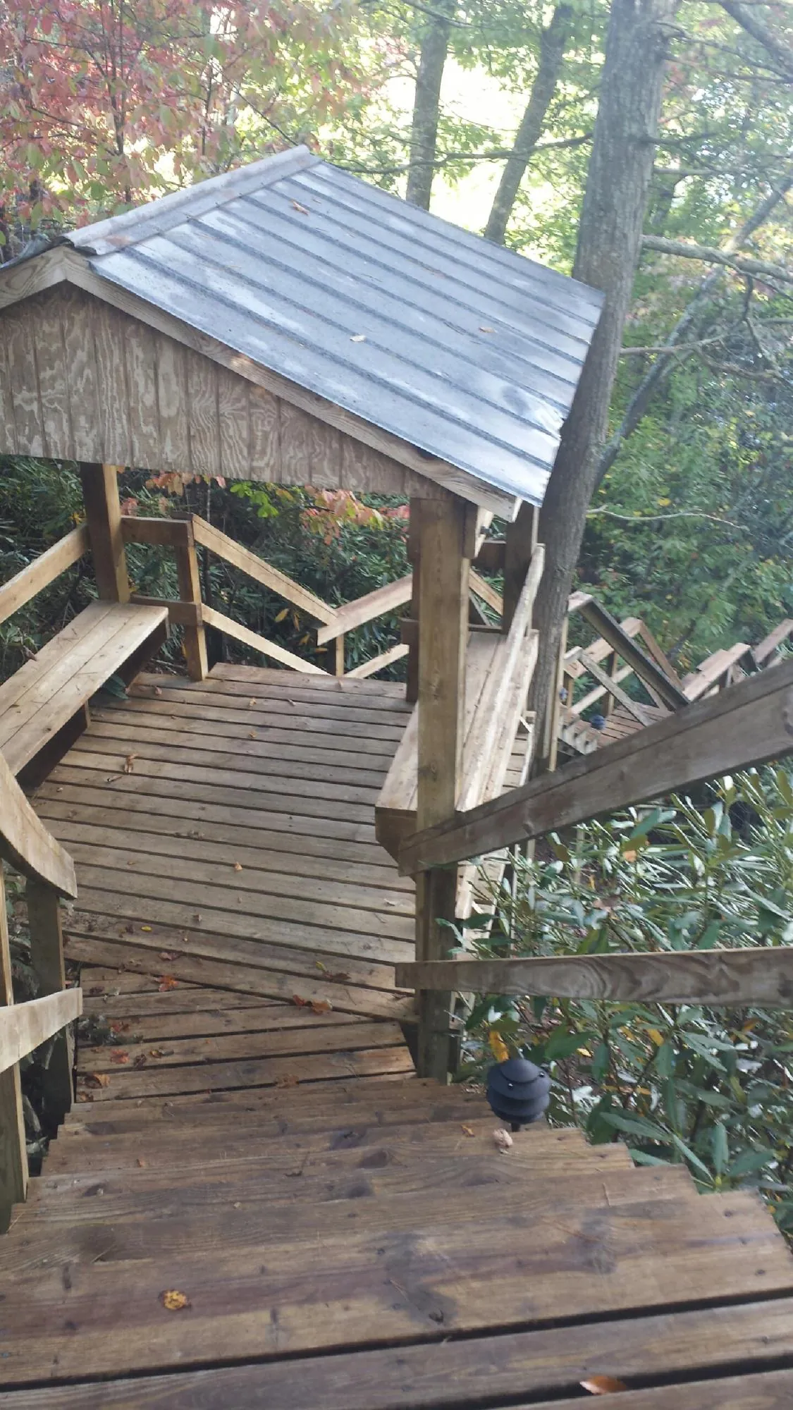 Metal roofed shelter over wooden steps on a wooded walkway — Skylight Repair & Installation work by our crew in Ossining